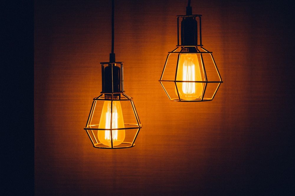 Black cage pendant lights glowing warmly